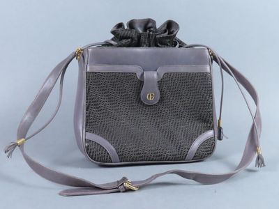 un sac à main gris et noir orné d'un nœud sur la poignée