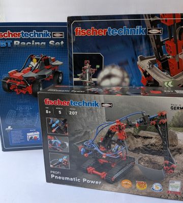 trois boîtes de lego technics exposées sur une table