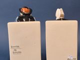 two ceramic figurines of a man and a woman sitting on top of each other