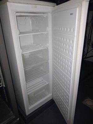 un réfrigérateur blanc dont la porte est ouverte, dans une pièce