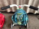 une boîte à outils rouge et un tuyau bleu posés par terre