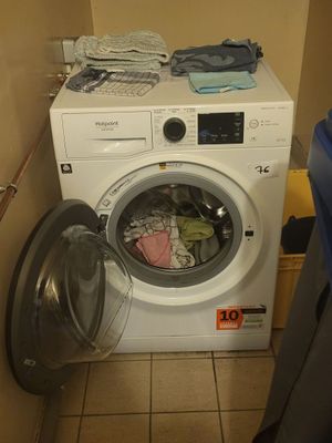 a washing machine in the corner of a small room