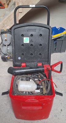a red bucket with a hose in it sitting on the floor