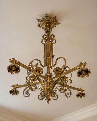 un lustre en or suspendu au plafond d'une pièce