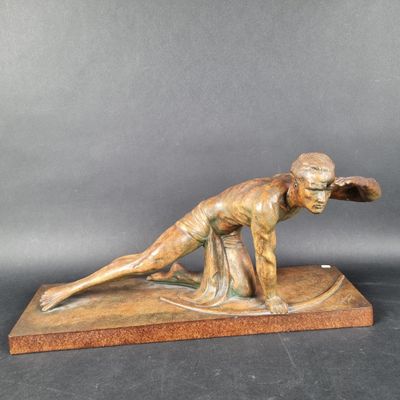 statue en bronze représentant un homme sur une planche de surf, posée sur un socle en marbre