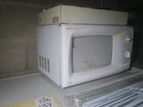 a white microwave sitting on top of a counter next to a stack of books