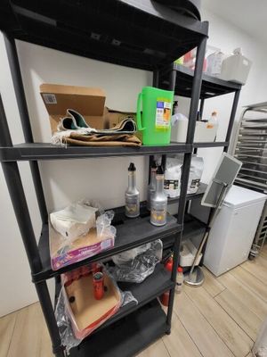 a black shelf with many items on it in a room