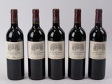 quatre bouteilles de vin sont alignées sur une surface blanche