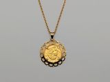 a gold necklace with a coin on a chain