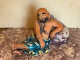 a figurine of a man sitting on a bed