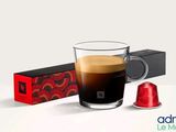 une tasse de café à côté d'une boîte de dosettes de café
