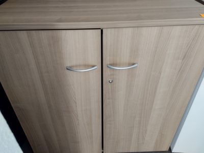 a cabinet with two doors and a drawer on top of it