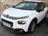 a small white car parked on the side of the road