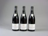 trois bouteilles de vin sont alignées sur une table