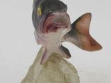 statue of a fish on a rock with its mouth open