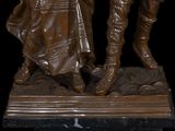 a bronze statue of a man and a woman holding hands