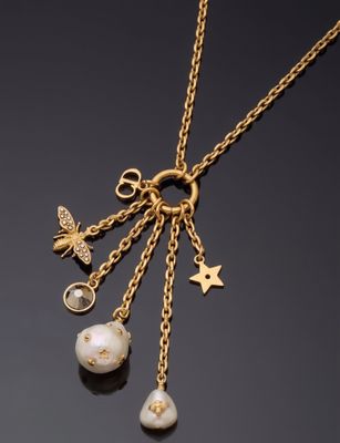 un gros plan sur un collier plaqué or orné de perles et de breloques