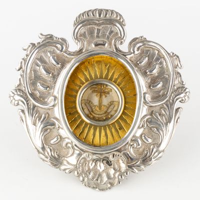 a silver and gold brooch with a picture of a lion