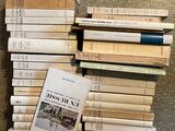 many books stacked on top of each other on the floor