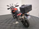 a motorcycle parked in a room with a luggage case on the back of it