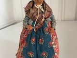 an image of a doll of an old woman in a blue dress