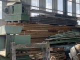 un gros tas de bois dans un entrepôt, à côté d'une machine