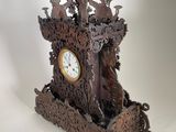 a clock that is sitting on a stand on a white surface