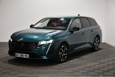 La voiture verte est garée dans une pièce au sol à carreaux.