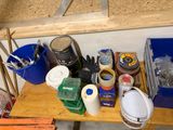 a wooden shelf with buckets, cans, and other items on it