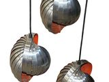three metal pendant lights hanging from a wire on a white background