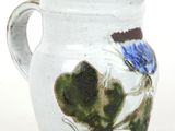 a white vase with a blue flower painted on it