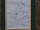 drawing of a man reading a book in a green frame on a wood floor