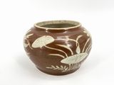 a brown vase with white designs on it on a white surface