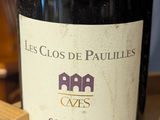 a bottle of wine sitting on a table next to a wooden block