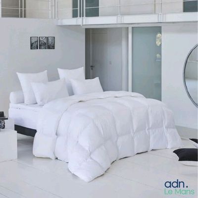a white bed in a room with a balcony above it