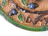 a close up of a decorative plate with a bird on it