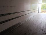 an image of a long empty room with a light at the end of it
