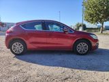 a red car parked in a parking lot next to a tree