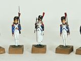four figurines of soldiers in uniform standing on wooden bases