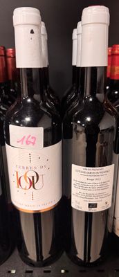 several bottles of wine are lined up on a shelf in a store