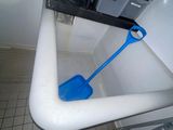 une pelle bleue posée dans une baignoire