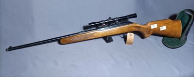 the rifle is laying on the table next to the hat