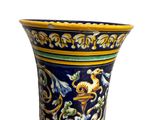 a blue vase with yellow and green designs on it
