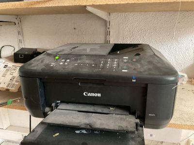 une imprimante Canon posée sur un bureau, à côté d'une autre imprimante