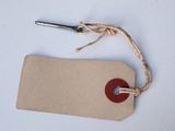 a brown tag with a red button on it