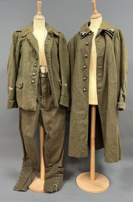 Deux uniformes militaires sont exposés sur un présentoir à mannequin