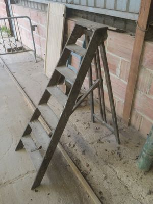une échelle appuyée contre un mur de briques près d'une fenêtre
