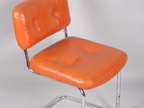 an orange chair with a metal frame on a white background