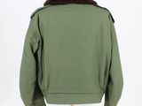 the back of a green jacket with a fur collar on a mannequin stand