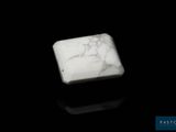 un bloc de marbre blanc posé sur une surface noire